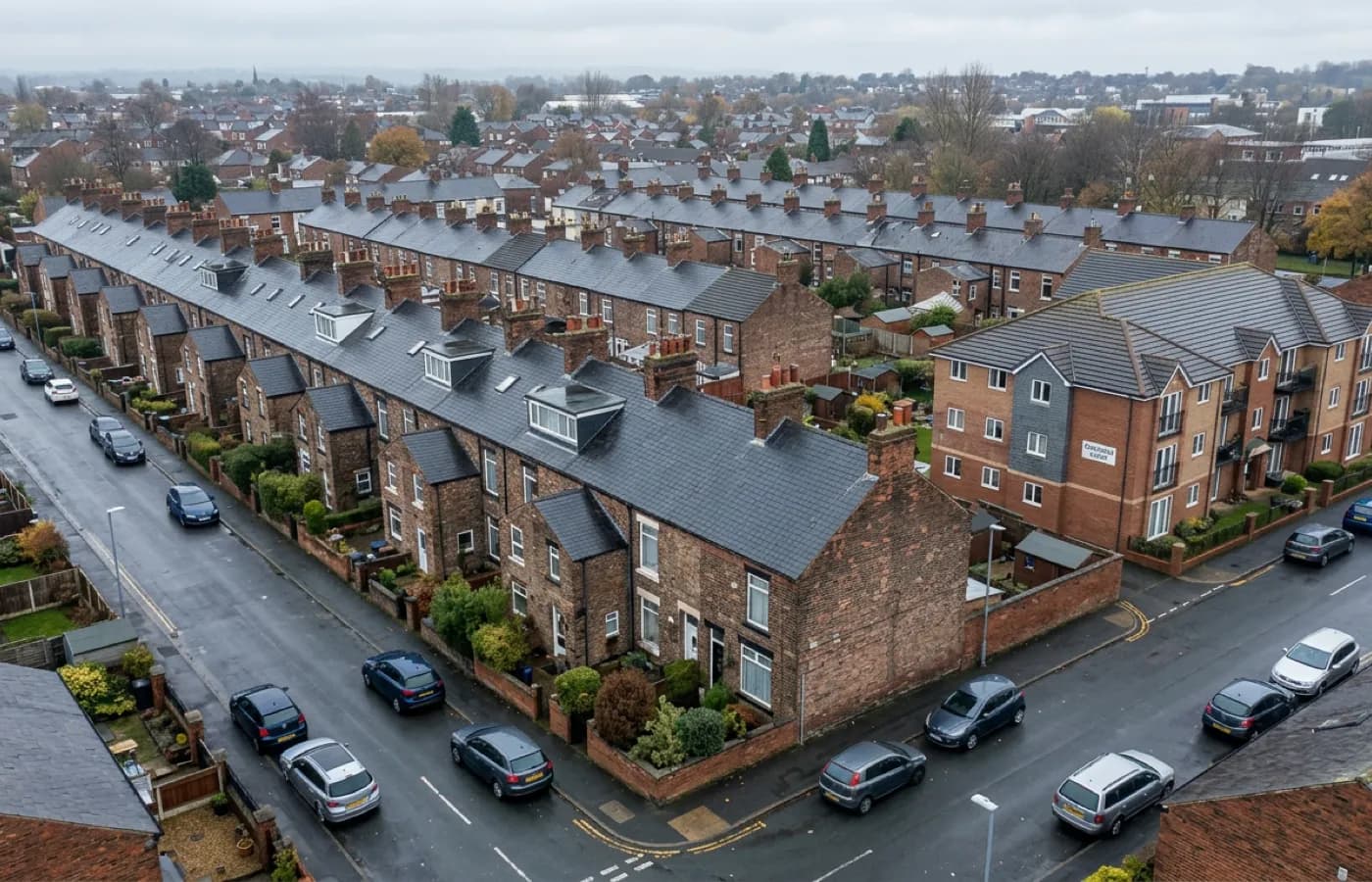 A row of let residential properties seen from above with a survey drone in frame, showing several roofs coverable without scaffolding outside any of them